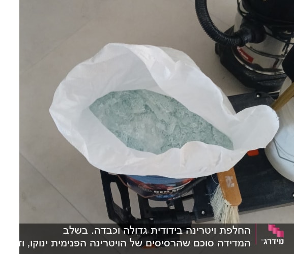שקית עם שברי זכוכית ושואב אבק על הרצפה